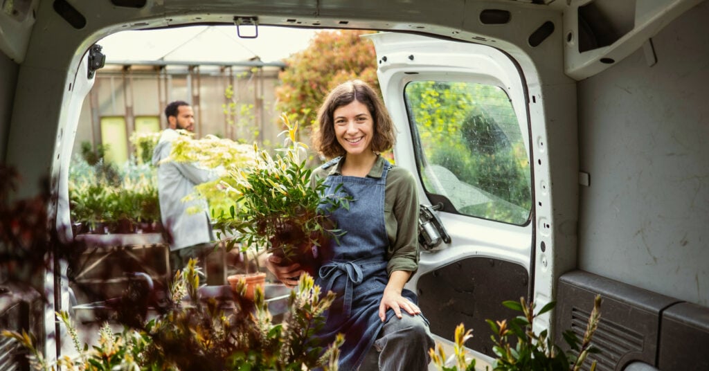 Small business owner unloading van representing business growth