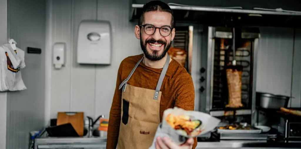 franchise owner shows off their food with a smile