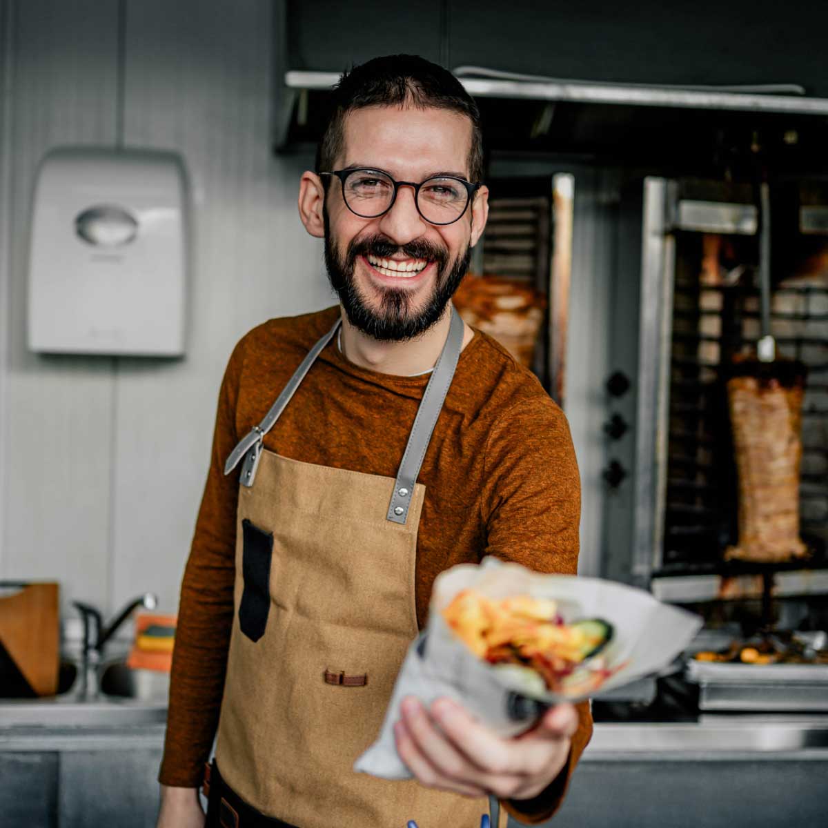 franchise owner shows off their food with a smile