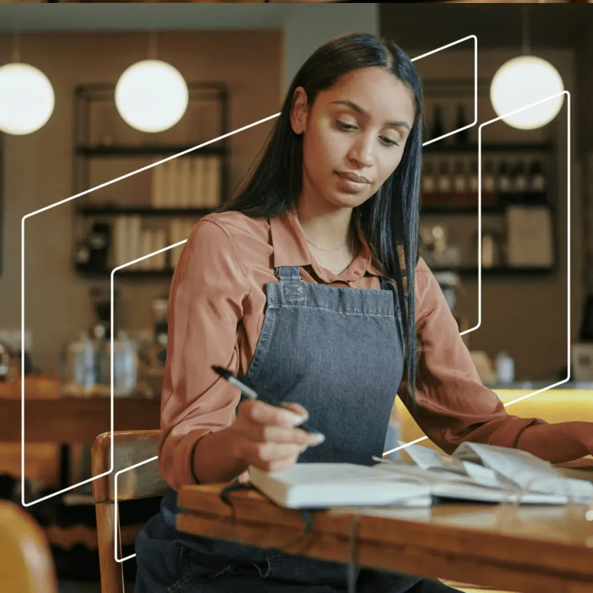 Young business woman in apron writing notes down