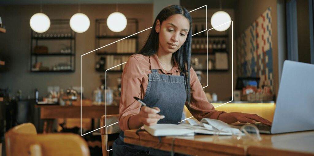 Young business woman in apron writing notes down