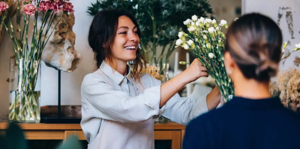 Young woman organises flowers at place of work