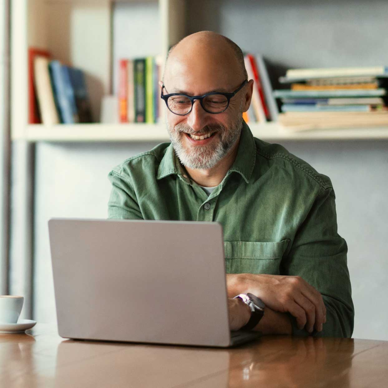Small business owner working on a laptop at a desk in a home office.